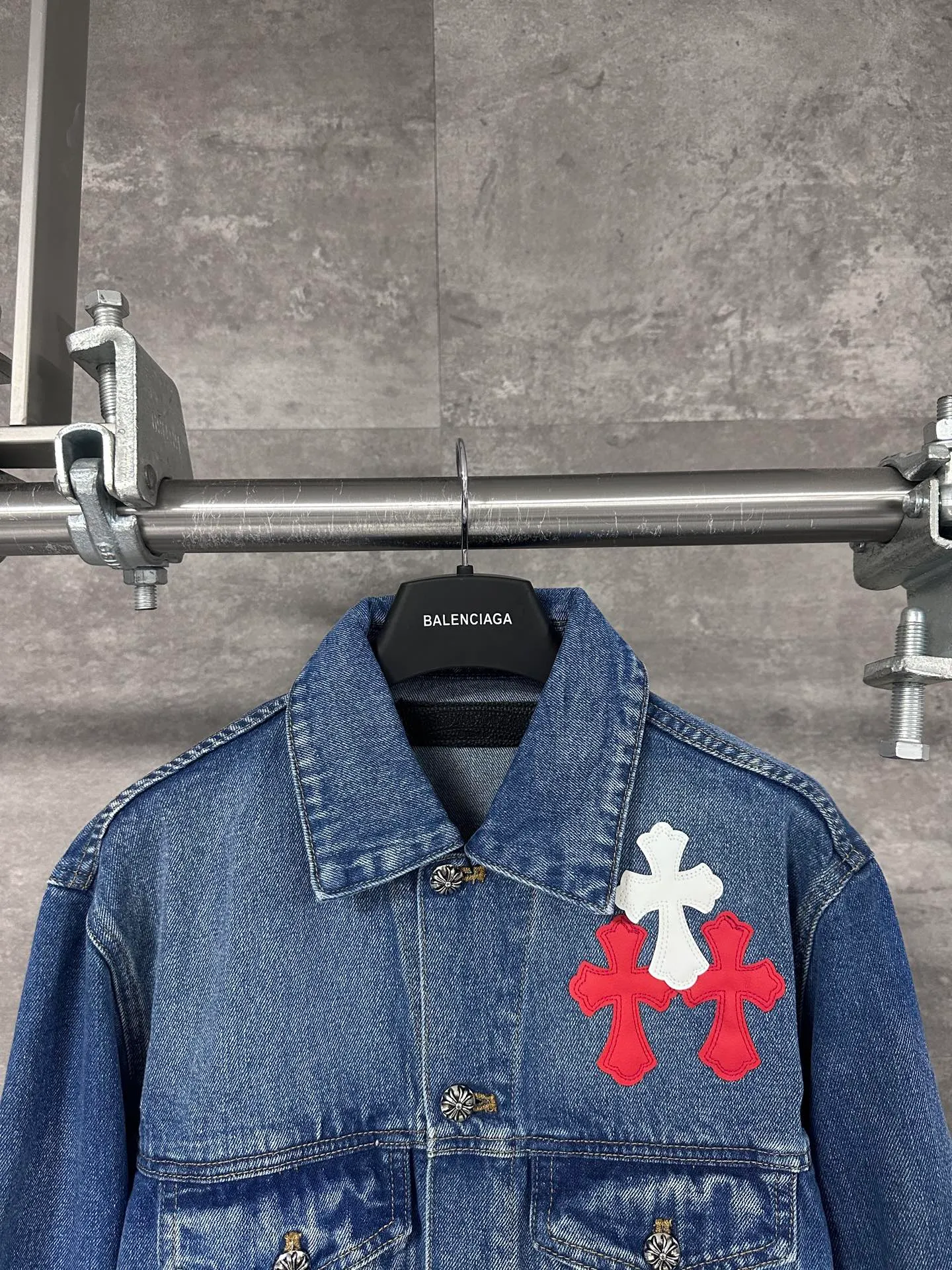 P720 CHrome Hearte cross patchwork leather denim jacket size: S M L Design details: the visual fantasy of Gothic symbols, the multi-dimensional expression of the cross totem: the red and white contrasting cross patches are staggered on the chest and back, making the brand more recognizable; the hollow cross pattern leather splicing on the sleeves combines the mystery of religious symbols with the punk-style deconstructed design. Every detail tells the dark aesthetics of Crowe's heart. Retro distressing with denim texture: Selected denim fabrics are treated with distressing techniques to show natural fading and texture, which not only retains the retro accent of denim items, but also adds a casual sense to the overall look. The ingenuity of hardware and tailoring: The metal buttons and hardware all have Croxin's iconic pattern, which shines exquisitely under the refraction of light; the neat tailoring of the classic denim jacket is suitable for a variety of wearing scenarios, and can create a strong personal style whether it is layered or worn alone. Croxin's denim jacket is not only a piece of clothing, but also a style badge that highlights unique aesthetics and rebellious attitude. For those who pursue individuality, they can leave their own hardcore mark in the fashion field.